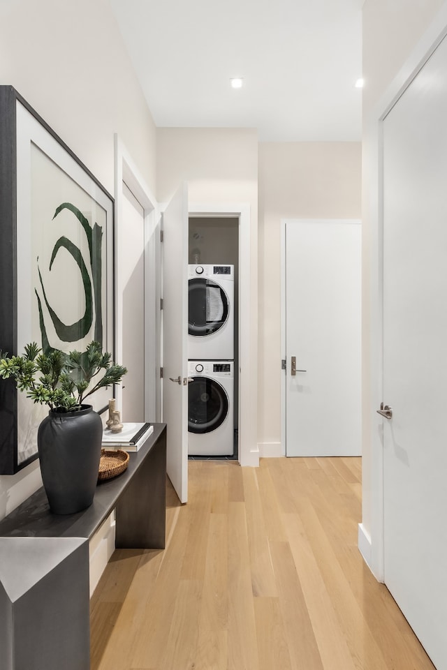 hallway featuring stacked washer / dryer, recessed lighting, and light wood-style floors