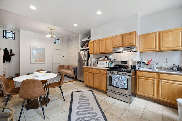 kitchen with under cabinet range hood, decorative backsplash, stainless steel appliances, and a sink