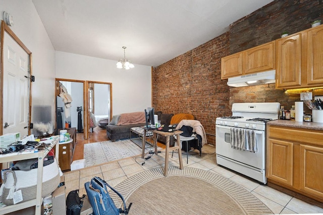 288 Mc Guinness Blvd Unit 1, 2, 3, New York City, NY 11222 - kitchen with gas range gas stove, under cabinet range hood, a chandelier, brick wall, and light tile patterned floors