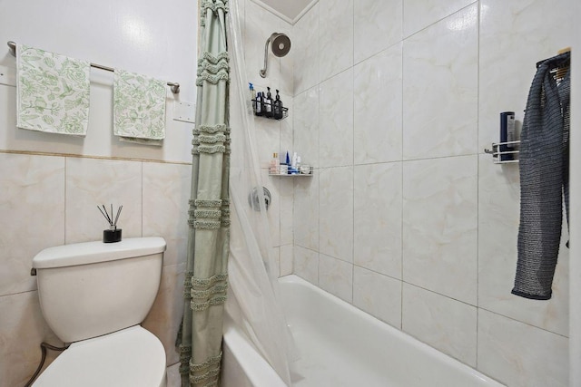 bathroom featuring shower / bath combo with shower curtain, toilet, and tile walls