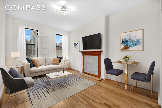 living room featuring a tiled fireplace, wood finished floors, and baseboards