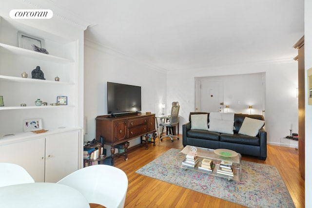 living room featuring wood finished floors, visible vents, and ornamental molding