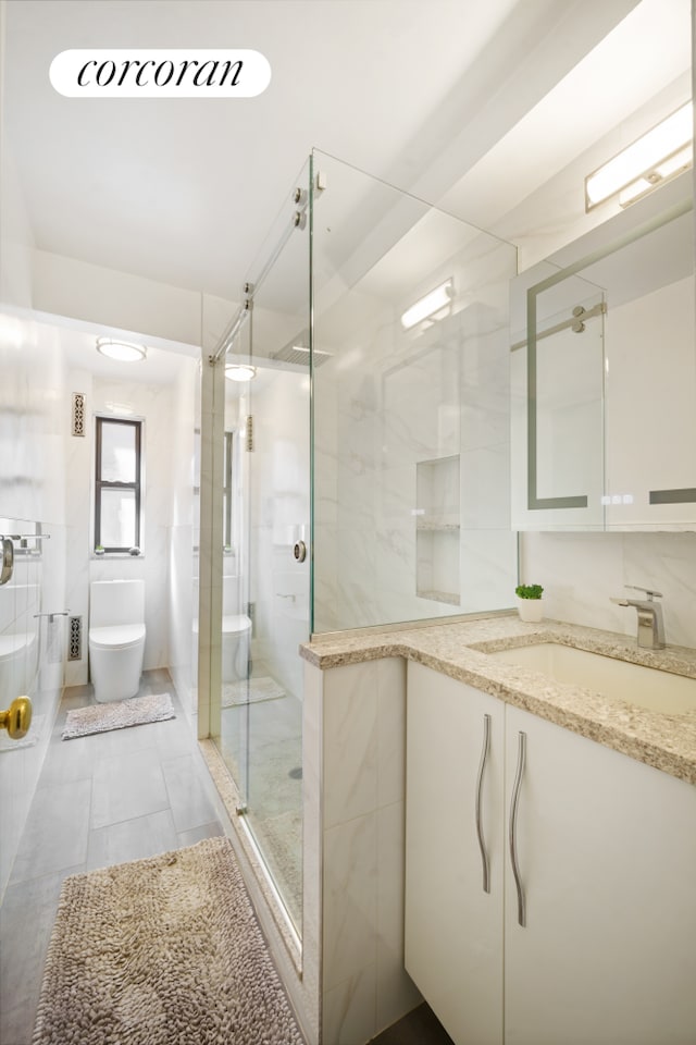 full bathroom with vanity, toilet, tile walls, and a shower stall