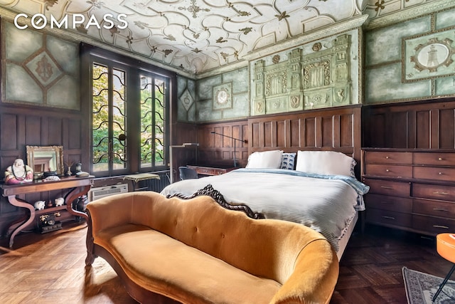 bedroom featuring a wainscoted wall, wallpapered walls, and a decorative wall