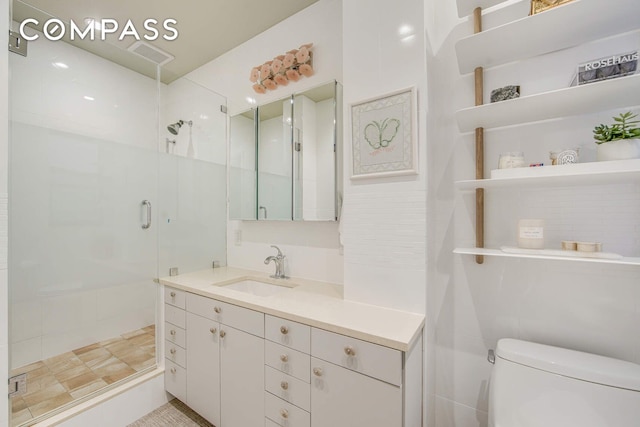 bathroom featuring a shower stall, vanity, visible vents, and toilet