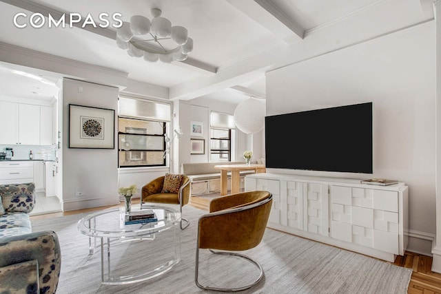 living room featuring baseboards, light wood finished floors, beam ceiling, crown molding, and a notable chandelier