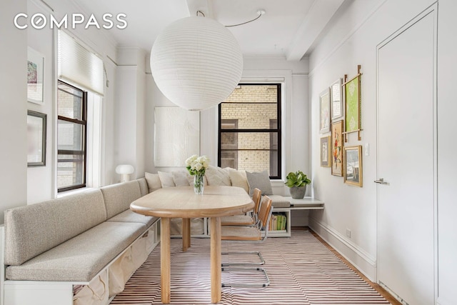 dining space featuring breakfast area, crown molding, and baseboards