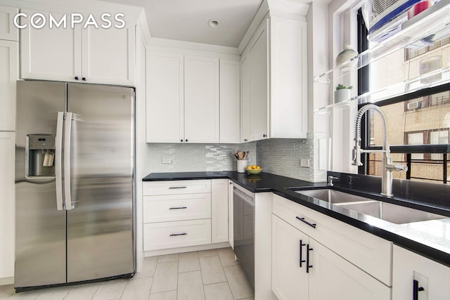 kitchen featuring backsplash, white cabinets, stainless steel refrigerator with ice dispenser, and a sink