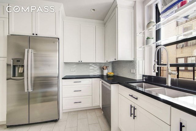 kitchen with stainless steel fridge with ice dispenser, a sink, a wealth of natural light, white cabinetry, and decorative backsplash