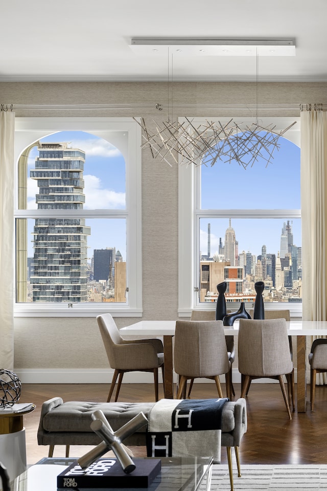 dining room with baseboards, a city view, and wood finished floors