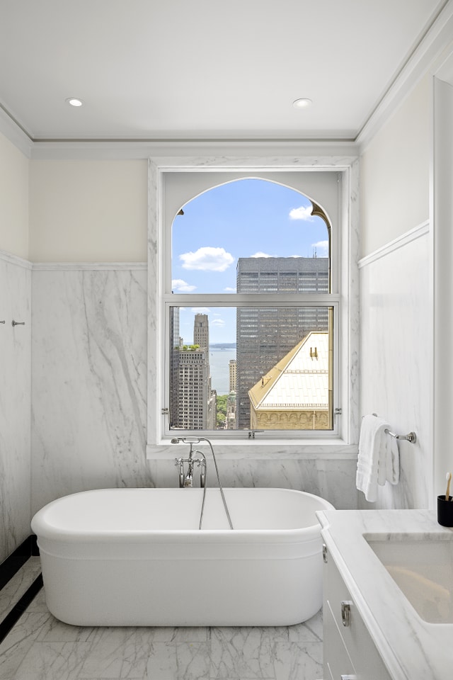 full bath featuring vanity, a soaking tub, recessed lighting, a city view, and marble finish floor