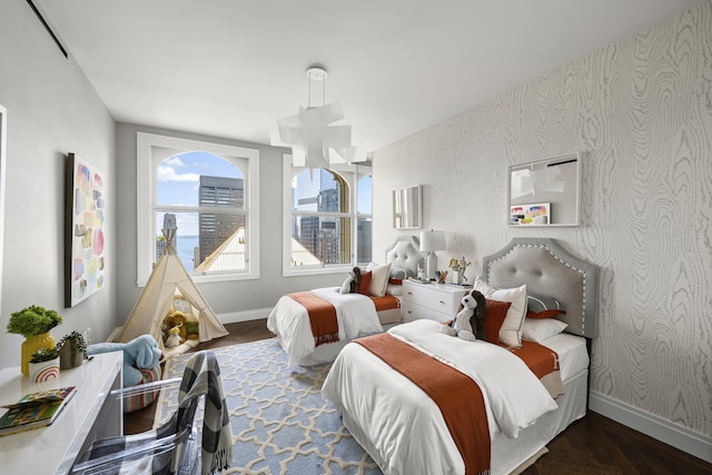 bedroom with wallpapered walls, wood finished floors, and baseboards