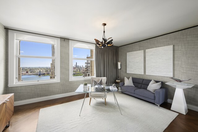 living area featuring baseboards, an inviting chandelier, and wallpapered walls