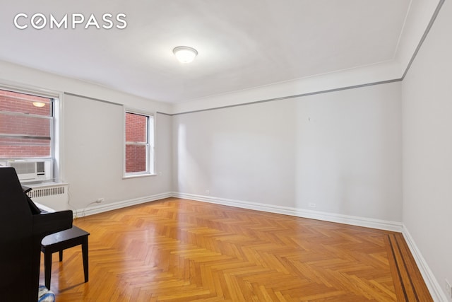 unfurnished room with baseboards and cooling unit