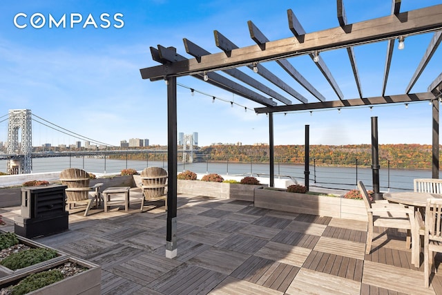 view of patio with a water view, a city view, and a pergola