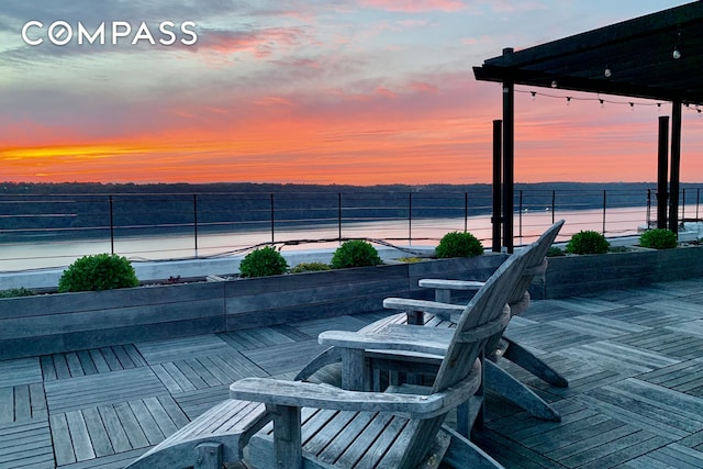 patio terrace at dusk with a water view and fence