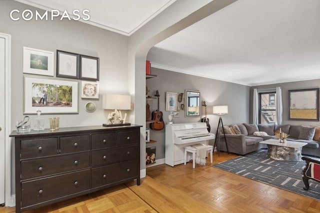 living area with baseboards, arched walkways, and ornamental molding