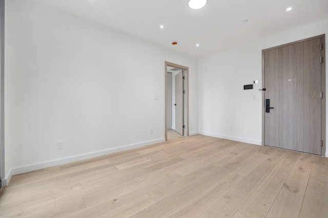 unfurnished room with recessed lighting, baseboards, and light wood-type flooring