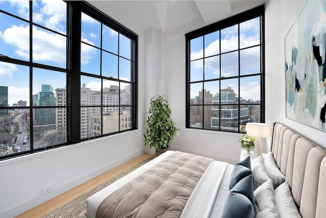 bedroom with a city view and wood finished floors