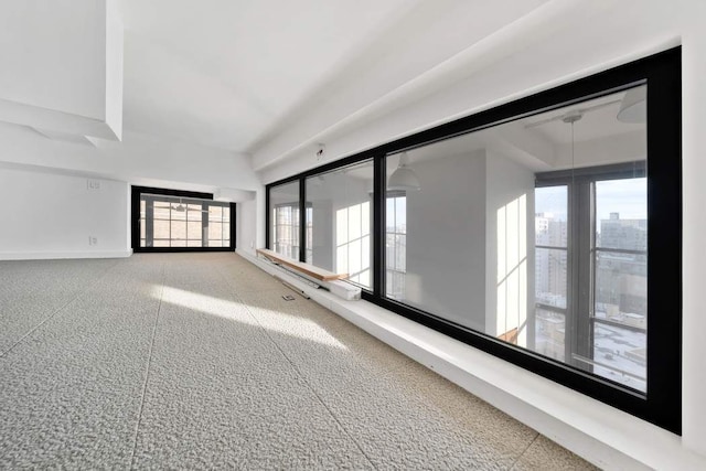 unfurnished room with a city view and baseboards