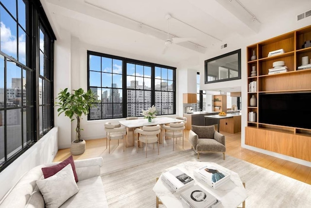 living area featuring built in shelves, wood finished floors, visible vents, ceiling fan, and track lighting