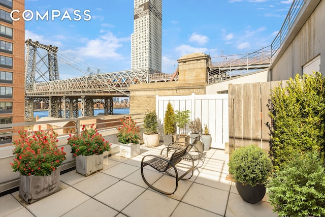 view of patio / terrace with a water view and fence