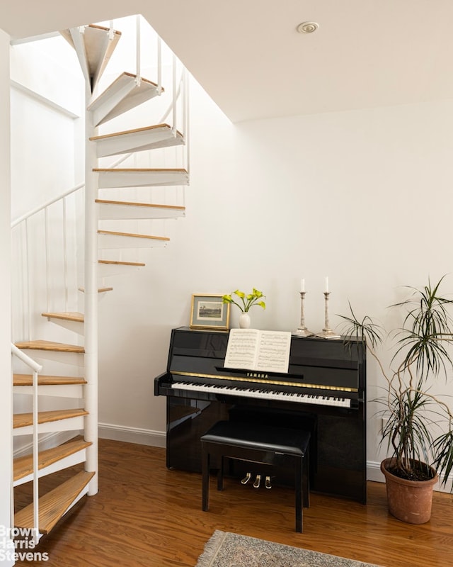 sitting room with baseboards, wood finished floors, and stairs