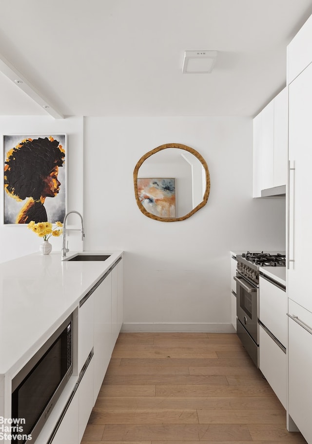 301 W 53rd St Unit 10I, New York City, NY 10019 - kitchen with appliances with stainless steel finishes, a sink, modern cabinets, and white cabinets