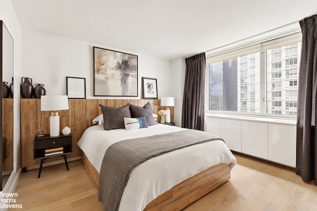 301 W 53rd St Unit 10I, New York City, NY 10019 - bedroom with light wood-style floors and a wainscoted wall