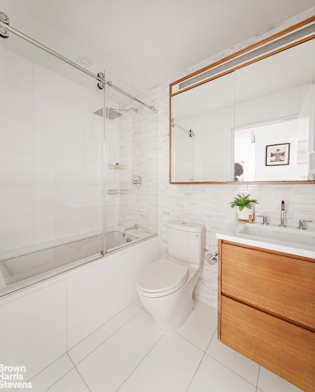 301 W 53rd St Unit 10I, New York City, NY 10019 - full bath with tile walls, tile patterned flooring, vanity, shower / bath combination with glass door, and toilet
