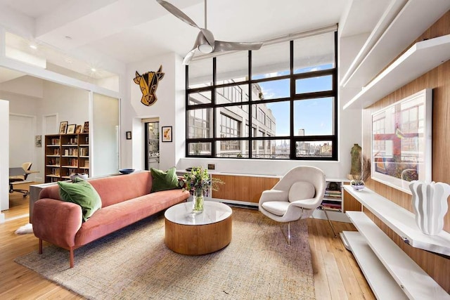 living area with hardwood / wood-style flooring and a high ceiling