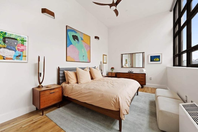 bedroom with baseboards, light wood-style floors, and ceiling fan