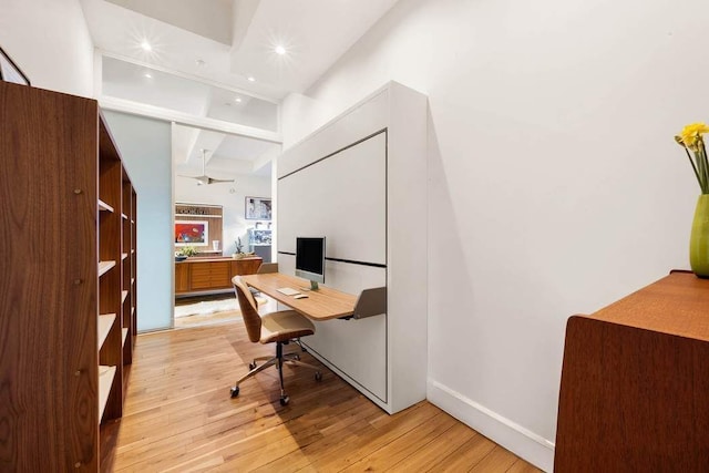 office area with recessed lighting, baseboards, light wood-type flooring, and a high ceiling