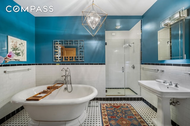 bathroom featuring a shower stall, tile walls, and tile patterned floors