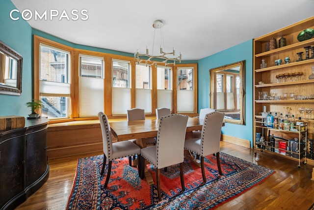 dining area with a chandelier, plenty of natural light, and wood-type flooring