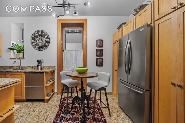 kitchen with light stone countertops, open shelves, freestanding refrigerator, a sink, and light speckled floor