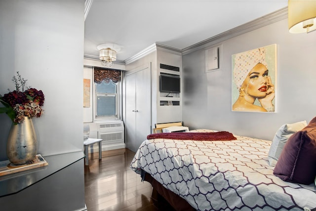 bedroom with a wall unit AC, ornamental molding, wood finished floors, a closet, and a notable chandelier