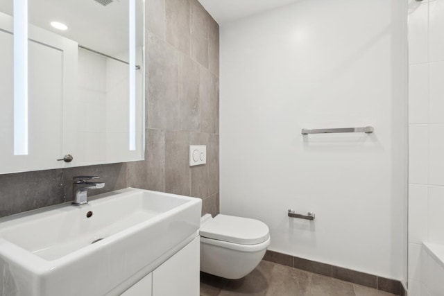 bathroom with tile patterned flooring, toilet, vanity, and baseboards