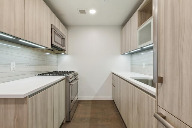 kitchen with visible vents, light brown cabinets, light countertops, stainless steel appliances, and modern cabinets