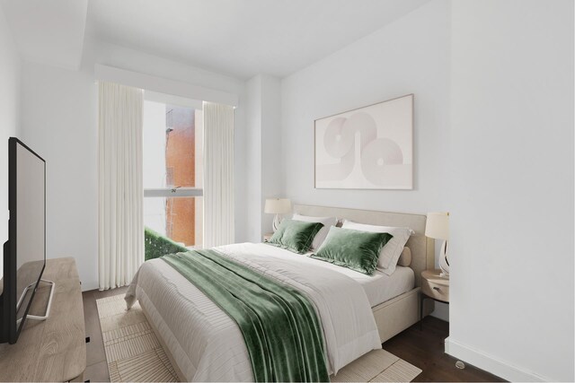 bedroom with baseboards and wood finished floors