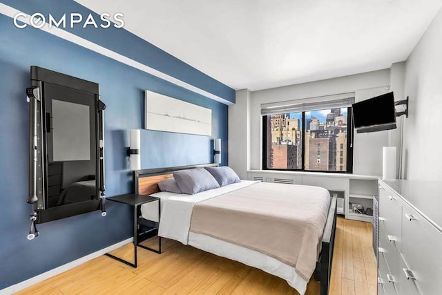 bedroom featuring wood finished floors and baseboards