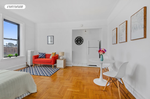 interior space with radiator heating unit, baseboards, visible vents, and freestanding refrigerator