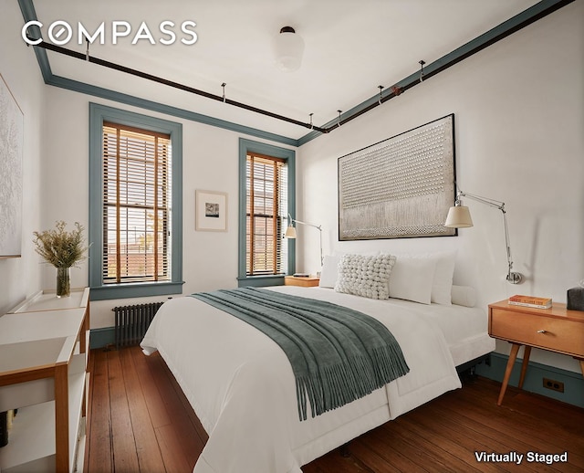 bedroom with hardwood / wood-style flooring, radiator, and ornamental molding