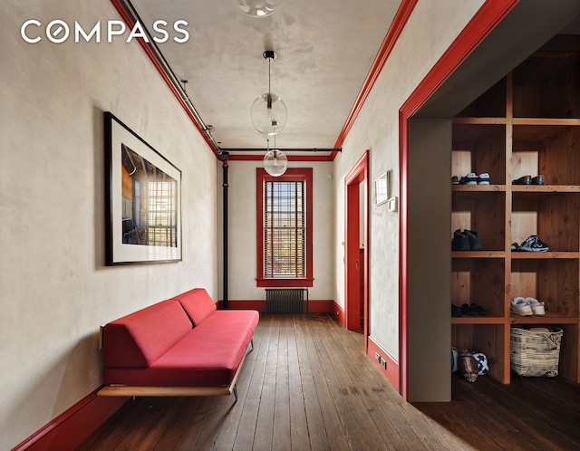 corridor with hardwood / wood-style flooring, radiator, crown molding, and baseboards