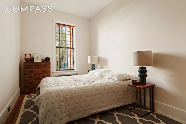 bedroom with wood finished floors and baseboards