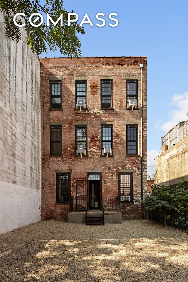 rear view of house with brick siding and cooling unit