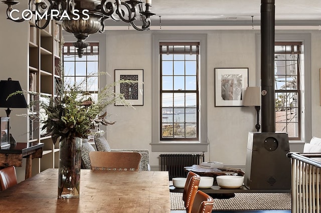 dining area featuring radiator heating unit and an inviting chandelier