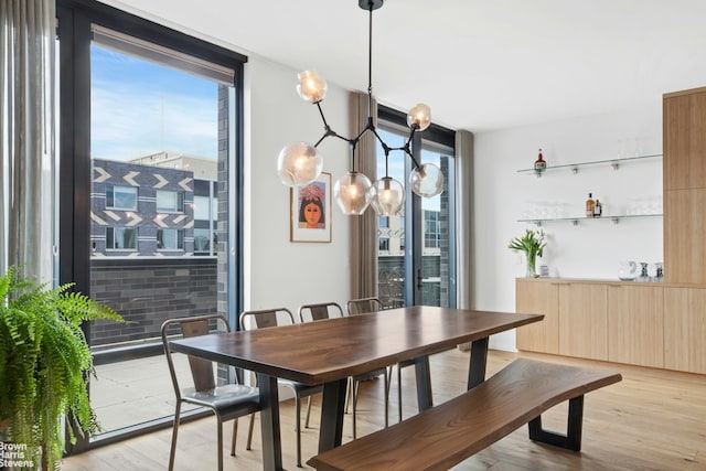 dining space with a wall of windows and light wood-style flooring