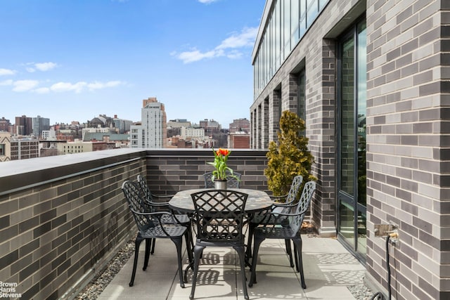 balcony featuring a city view and outdoor dining space