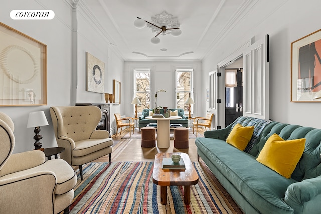 living area featuring visible vents, wood finished floors, and ornamental molding